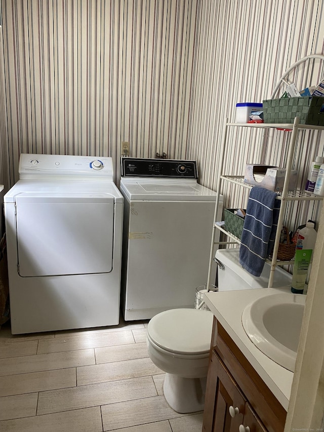 1248 Valley Rd, Fairfield, CT 06825 - bathroom with wallpapered walls, independent washer and dryer, toilet, vanity, and wood finished floors