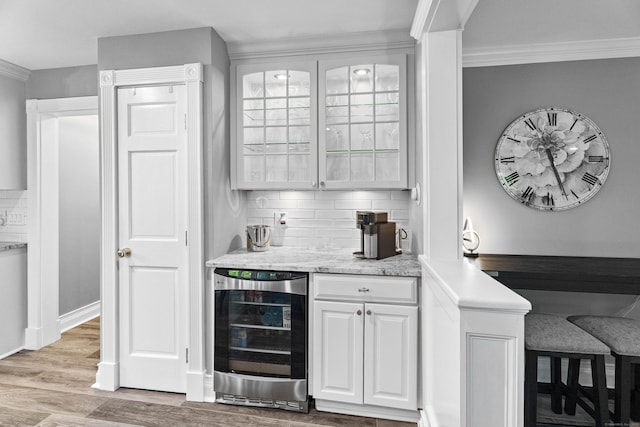 8A Russett Rd, Newtown, CT 06482 - indoor wet bar featuring wine cooler, decorative backsplash, light wood-style flooring, and crown molding