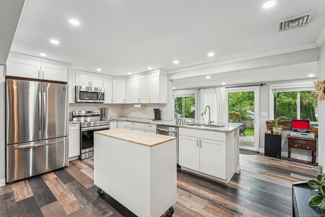 288 Robbins Ave, Newington, CT 06111 - kitchen with stainless steel appliances, a peninsula, a sink, white cabinets, and ornamental molding