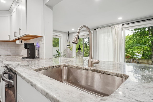 288 Robbins Ave, Newington, CT 06111 - kitchen with a sink, backsplash, light stone countertops, white cabinets, and recessed lighting