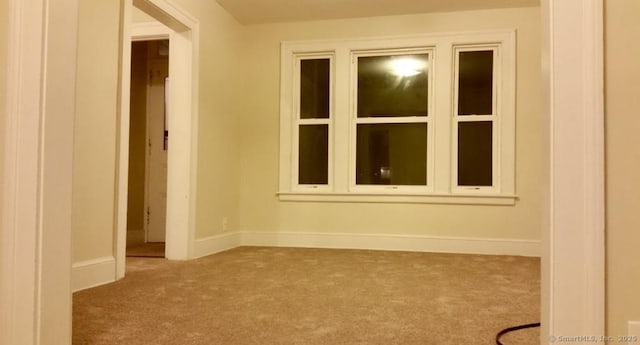 carpeted spare room with baseboards