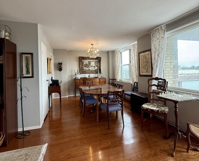 1 Strawberry Hill Ct Apt 6F, Stamford, CT 06902 - dining space with a chandelier, wood finished floors, a textured ceiling, and baseboards
