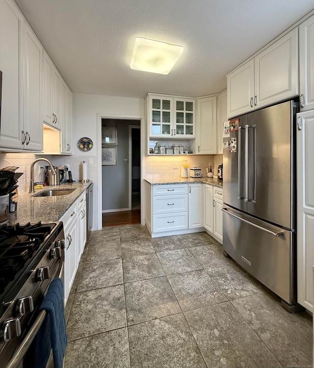 1 Strawberry Hill Ct Apt 6F, Stamford, CT 06902 - kitchen with appliances with stainless steel finishes, a sink, tasteful backsplash, white cabinets, and glass insert cabinets