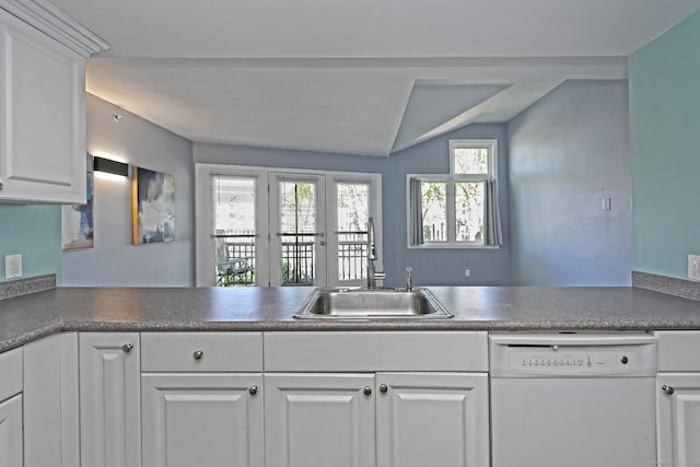 3250 Fairfield Ave Apt 302, Bridgeport, CT 06605 - kitchen with white dishwasher, a sink, white cabinetry, vaulted ceiling, and dark countertops