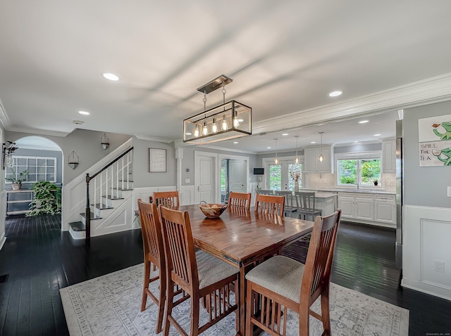 130 Wildewood Run, Bristol, CT 06010 - dining room with crown molding, stairs, dark wood finished floors, wainscoting, and arched walkways