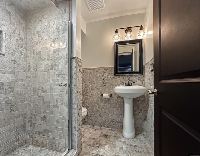 130 Wildewood Run, Bristol, CT 06010 - full bathroom featuring a shower stall, toilet, wainscoting, a sink, and tile walls