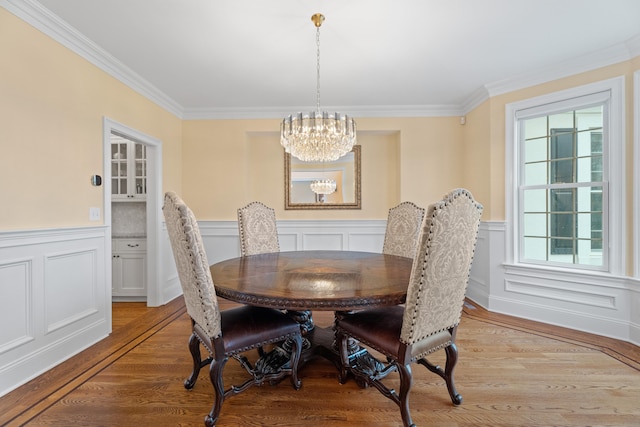 24 N Racebrook Rd, Woodbridge, CT 06525 - dining area with a chandelier, crown molding, light wood finished floors, a wainscoted wall, and a decorative wall