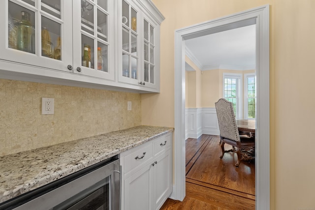 24 N Racebrook Rd, Woodbridge, CT 06525 - bar featuring beverage cooler, crown molding, dark wood-style floors, decorative backsplash, and a wainscoted wall