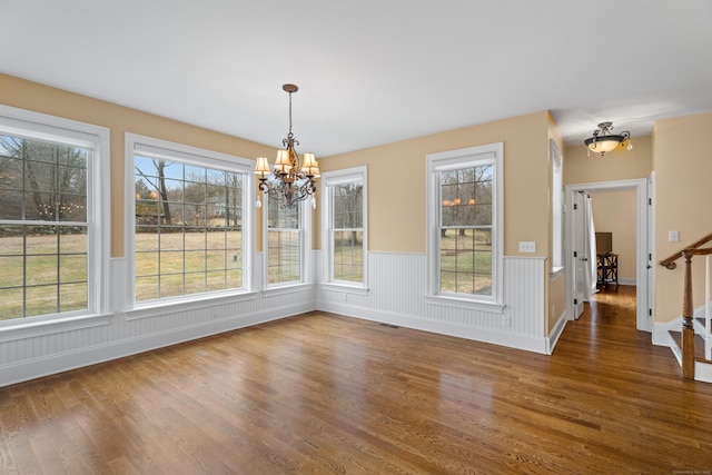 24 N Racebrook Rd, Woodbridge, CT 06525 - unfurnished dining area featuring a chandelier, wood finished floors, a wainscoted wall, and plenty of natural light