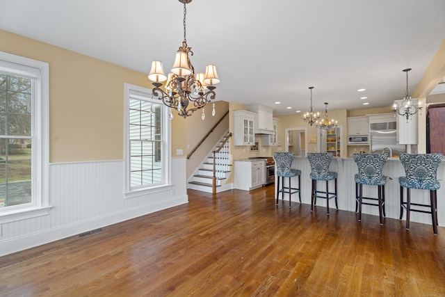24 N Racebrook Rd, Woodbridge, CT 06525 - kitchen featuring a chandelier, stainless steel appliances, a kitchen bar, custom range hood, and a wainscoted wall