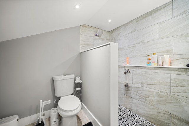 bathroom featuring a walk in shower, toilet, lofted ceiling, recessed lighting, and baseboards