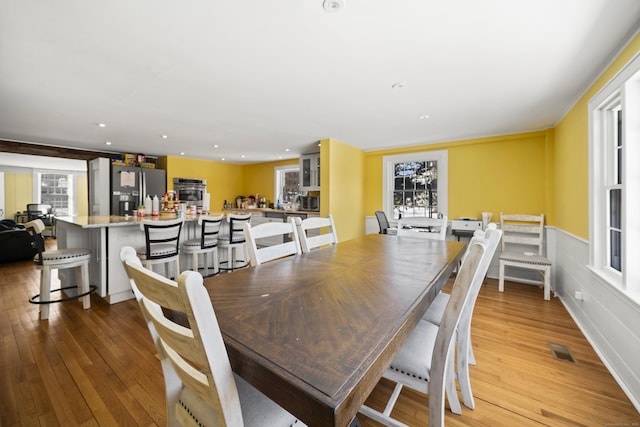 dining area with light wood finished floors and recessed lighting