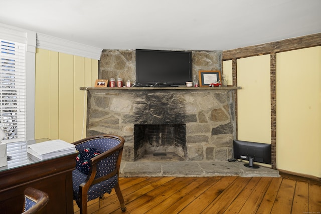 living area with hardwood / wood-style flooring and a fireplace