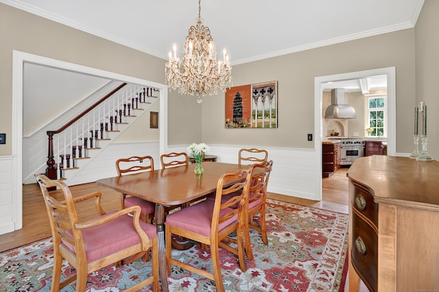 207 Great Pond Rd, Simsbury, CT 06070 - dining space featuring stairs, light wood-style floors, ornamental molding, a chandelier, and wainscoting