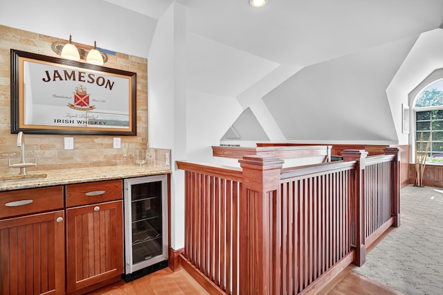 207 Great Pond Rd, Simsbury, CT 06070 - indoor wet bar with beverage cooler, backsplash, lofted ceiling, wainscoting, and light wood finished floors