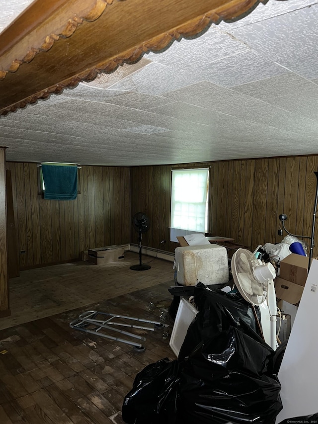 1100 Plainfield Pike, Sterling, CT 06373 - bedroom featuring wood-type flooring, wooden walls, and a baseboard heating unit