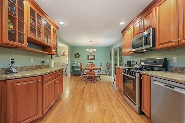 8 Brookview Ct, Bethel, CT 06801 - kitchen featuring stainless steel appliances, light wood-style floors, brown cabinetry, a chandelier, and recessed lighting