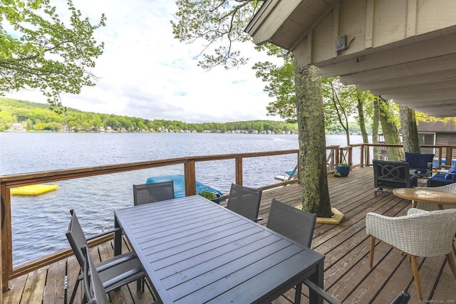 dock area featuring outdoor dining area and a deck with water view