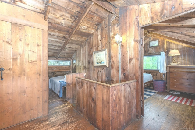 hall featuring lofted ceiling, hardwood / wood-style floors, wooden ceiling, and wood walls