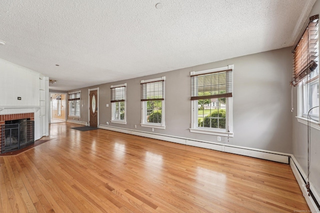 81 Edward St, Newington, CT 06111 - unfurnished living room featuring a textured ceiling, wood finished floors, a brick fireplace, and plenty of natural light