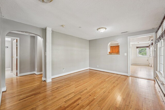 81 Edward St, Newington, CT 06111 - spare room featuring arched walkways, light wood-style floors, a textured ceiling, baseboards, and baseboard heating