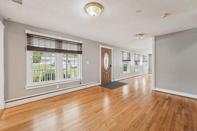 81 Edward St, Newington, CT 06111 - entrance foyer with baseboard heating, wood finished floors, a textured ceiling, and baseboards