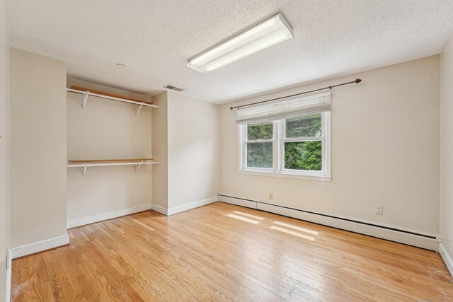 81 Edward St, Newington, CT 06111 - unfurnished bedroom featuring wood finished floors, a baseboard radiator, a textured ceiling, baseboards, and a closet