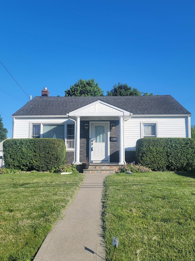 725 Merritt St, Bridgeport, CT 06606 - single story home with a front lawn, a chimney, roof with shingles, and stone siding