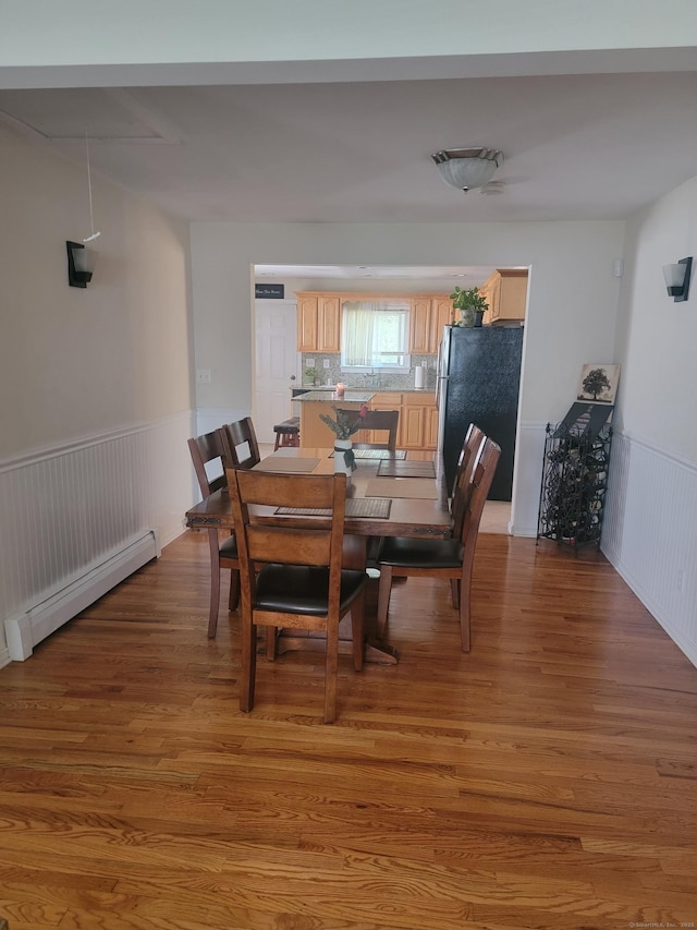 725 Merritt St, Bridgeport, CT 06606 - dining room featuring a baseboard radiator, wainscoting, and wood finished floors