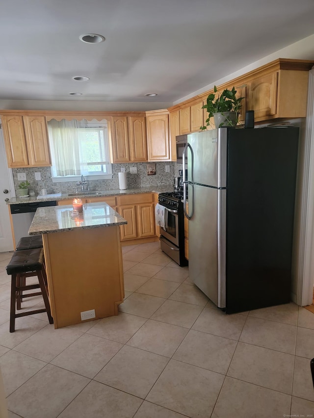725 Merritt St, Bridgeport, CT 06606 - kitchen with stainless steel appliances, light stone countertops, a center island, and backsplash
