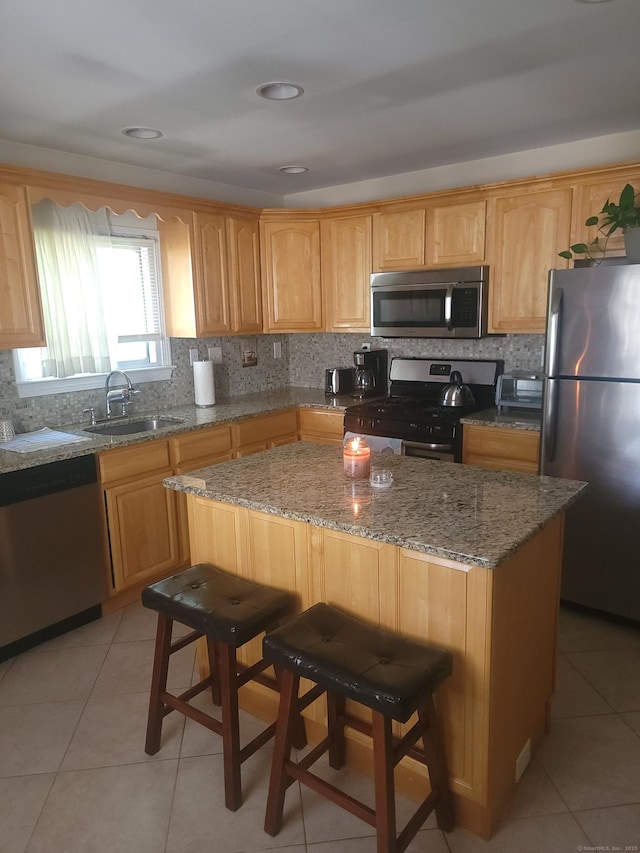 725 Merritt St, Bridgeport, CT 06606 - kitchen featuring appliances with stainless steel finishes, a sink, a kitchen breakfast bar, light tile patterned floors, and light stone counters