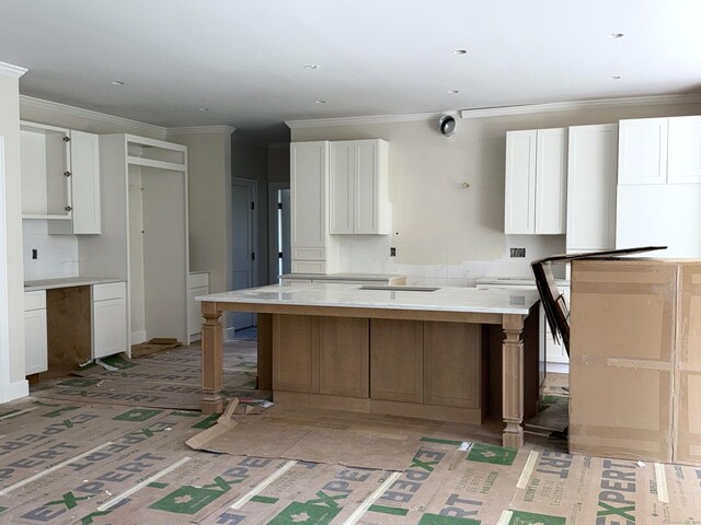 23 Melrose Dr, Cheshire, CT 06410 - kitchen featuring white cabinets, ornamental molding, a kitchen island, light countertops, and a kitchen breakfast bar