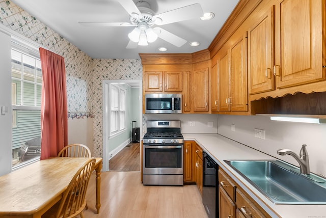 39 Woodcrest Ave, Stratford, CT 06614 - kitchen with stainless steel appliances, a sink, light wood-style floors, wallpapered walls, and ceiling fan