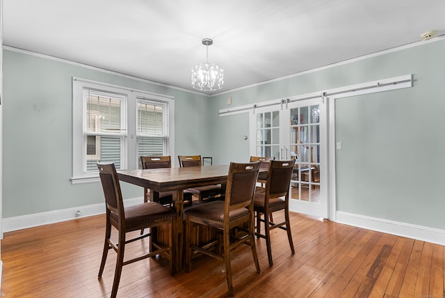 39 Woodcrest Ave, Stratford, CT 06614 - dining space with ornamental molding, baseboards, a barn door, a chandelier, and light wood-style flooring
