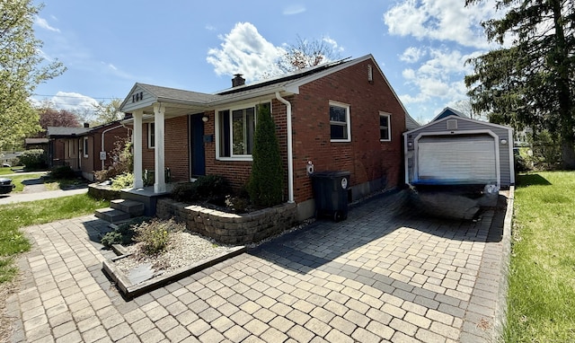 108 Dartmouth St, Torrington, CT 06790 - view of property exterior featuring a chimney, an outdoor structure, brick siding, decorative driveway, and a lawn