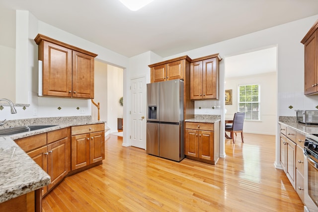 1 Chatham Ct Unit 1, Middlebury, CT 06762 - kitchen with stainless steel appliances, a sink, light wood-style floors, and brown cabinetry