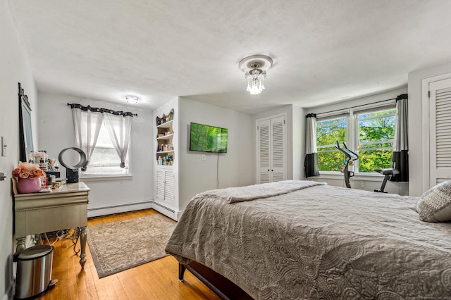 54 Swampscott Rd, Stamford, CT 06905 - bedroom featuring a baseboard radiator, hardwood / wood-style flooring, and two closets