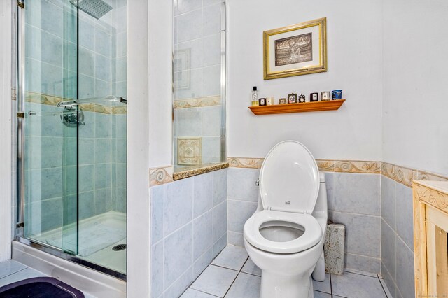 54 Swampscott Rd, Stamford, CT 06905 - full bathroom with tile walls, a stall shower, tile patterned flooring, wainscoting, and toilet