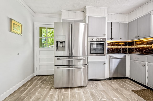 54 Swampscott Rd, Stamford, CT 06905 - kitchen featuring appliances with stainless steel finishes, dark countertops, light wood finished floors, baseboards, and ornamental molding