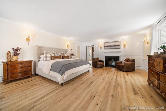 879 Russell Ave, Suffield, CT 06078 - bedroom featuring light wood-style flooring and a glass covered fireplace