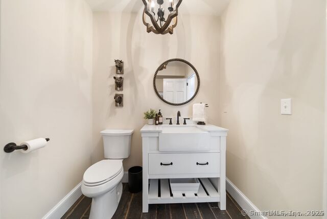 879 Russell Ave, Suffield, CT 06078 - bathroom featuring a chandelier, toilet, wood finished floors, vanity, and baseboards