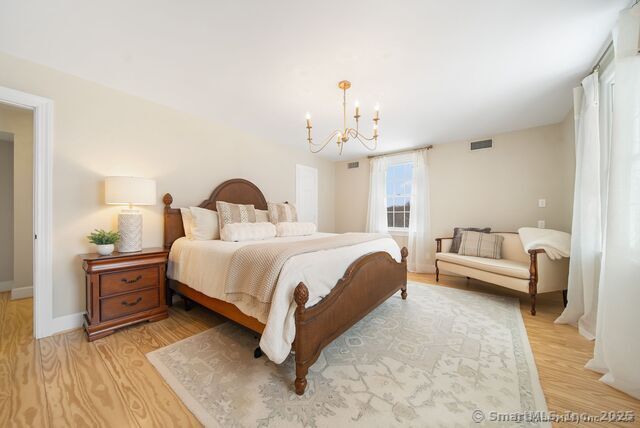 879 Russell Ave, Suffield, CT 06078 - bedroom with light wood-style flooring, a chandelier, and baseboards