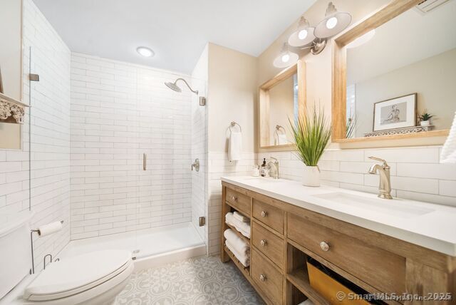 879 Russell Ave, Suffield, CT 06078 - bathroom featuring a shower stall, toilet, double vanity, and tile patterned floors