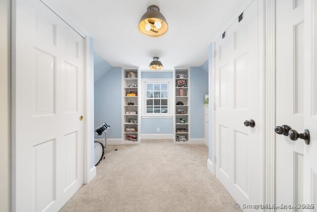 879 Russell Ave, Suffield, CT 06078 - hall with light colored carpet, baseboards, and built in features