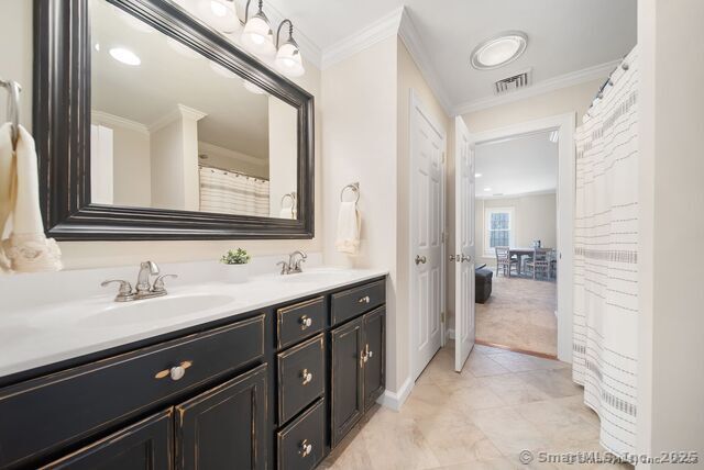 879 Russell Ave, Suffield, CT 06078 - bathroom with crown molding, double vanity, baseboards, and tile patterned flooring