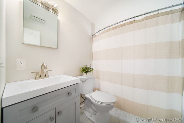 879 Russell Ave, Suffield, CT 06078 - bathroom featuring toilet, vanity, tile patterned floors, and a shower with shower curtain