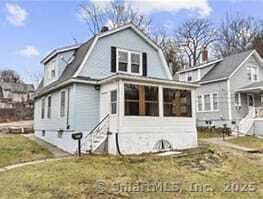 593 Cooke St, Waterbury, CT 06710 - back of property featuring a gambrel roof, a sunroom, and a lawn