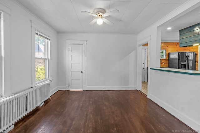593 Cooke St, Waterbury, CT 06710 - unfurnished living room with radiator, hardwood / wood-style flooring, crown molding, ceiling fan, and baseboards