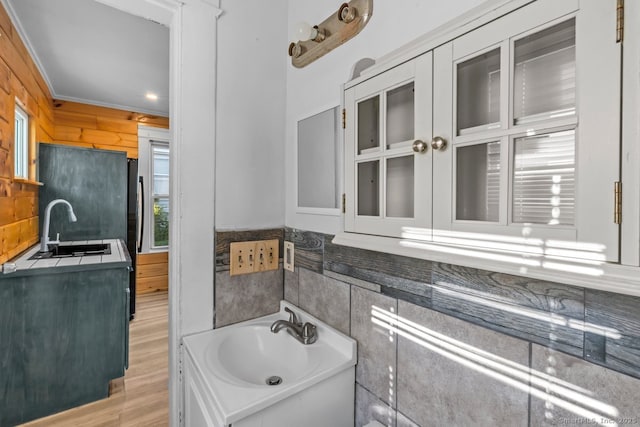 593 Cooke St, Waterbury, CT 06710 - bathroom with a sink, crown molding, tasteful backsplash, and wood finished floors