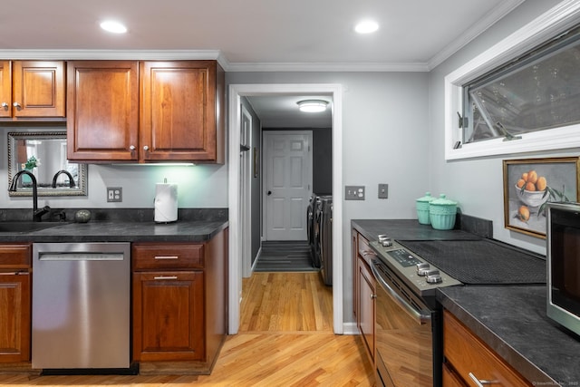 27 Pleasant Valley Rd, Barkhamsted, CT 06063 - kitchen featuring appliances with stainless steel finishes, washer and dryer, a sink, light wood-style floors, and brown cabinetry